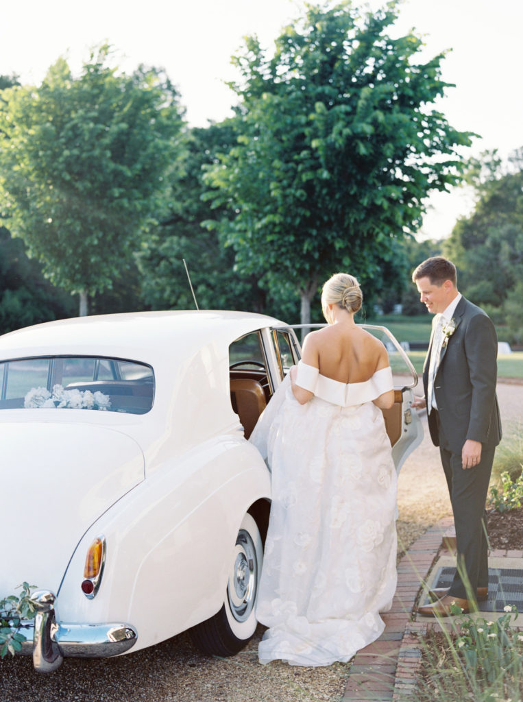 newlywed couple at pursell farms wedding, exiting in luxury vintage car.